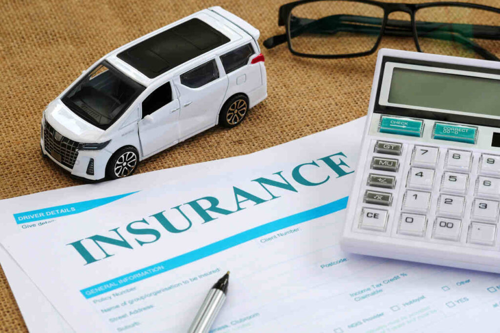 Car insurance document and travel themed toy car near the doc 