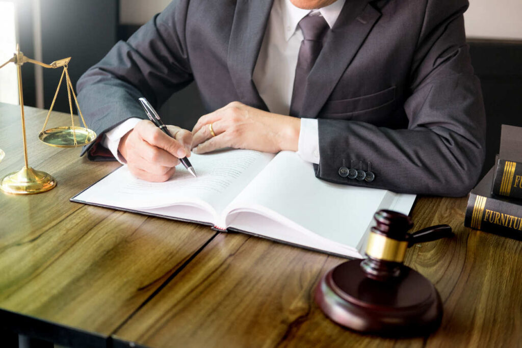 gavel on the top of the table and a lawyer writing in a doc representing an injury lawyer in TX.