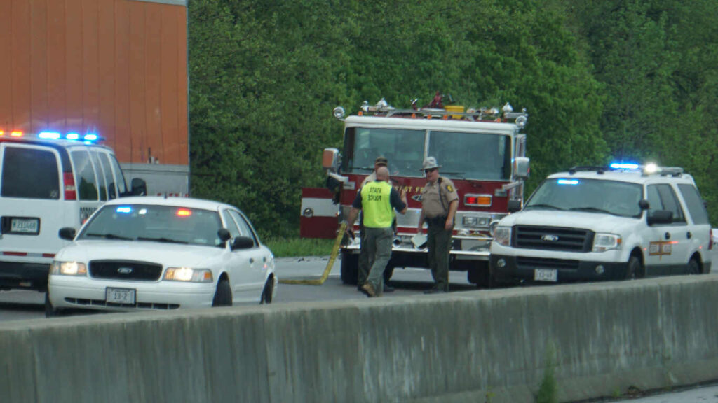 Police and first responders with flashing lights at the scene of a truck accident on a Texas highway.